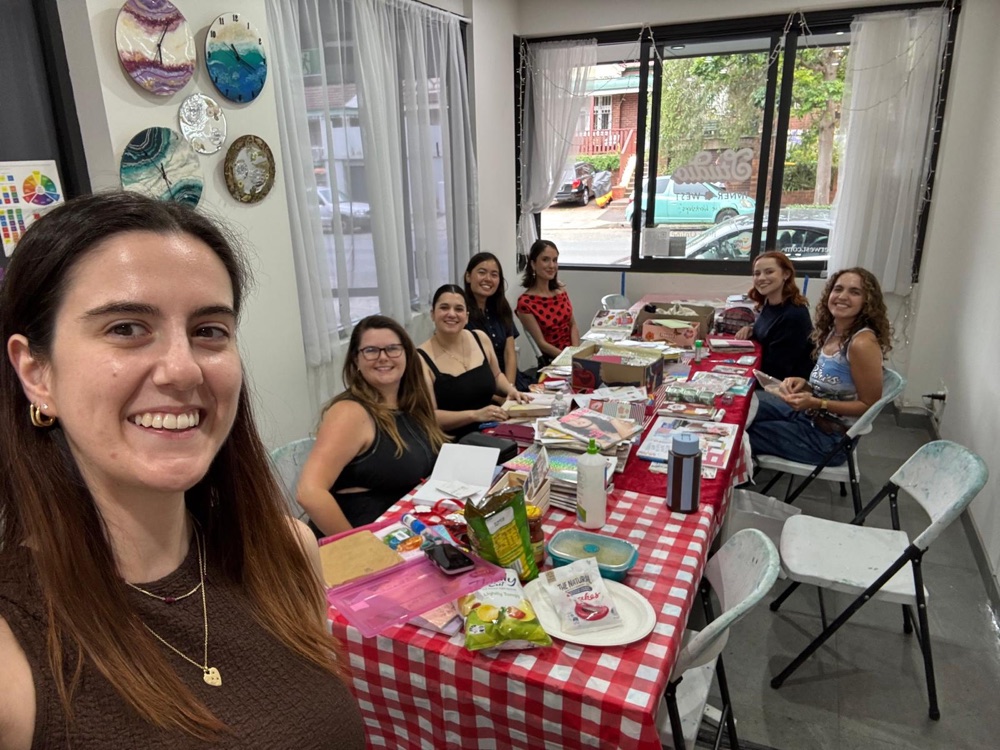 Lucy with a full table of students at a collage workshop in her studio